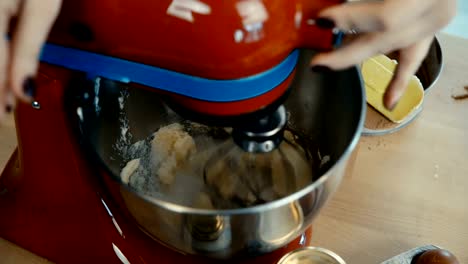 Nahaufnahme-von-weiblichen-Händen-schaltet-sich-der-Mixer-und-mischen-die-Butter-mit-dem-Zucker-zum-Backen.-Weiblich-Hobby-zu-tun