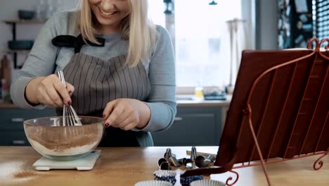 Junge-schöne-Frau-stehend-auf-die-Küche-und-Zutaten-in-einer-Schüssel-mischen,-mit-Nimbus,-kochen-die-desserts