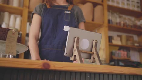 Cajero-de-tienda-de-delicatessen-birlar-la-tarjeta-en-la-tableta-Digital-en-el-mostrador