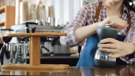 Barista-using-hand-held-coffee-grinder