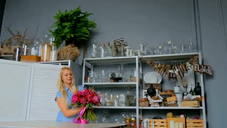 Professional-florist-holding-and-checking-bouquet-at-studio