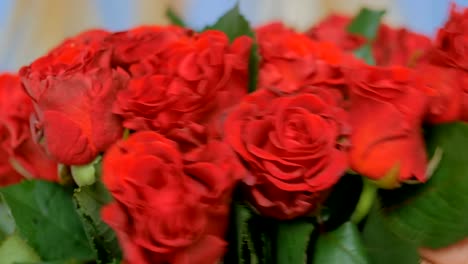 Professional-florist-preparing-red-roses-for-bouquet-at-workshop