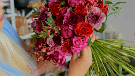 Professional-florist-holding-and-checking-bouquet-at-studio