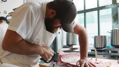 Metzger-Sägen-Fleisch-zu-verkaufen-in-einer-Metzgerei,-Nahaufnahme