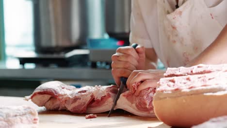 Butcher’s-hands-cutting-meat-at-a-butcher's-shop,-close-up