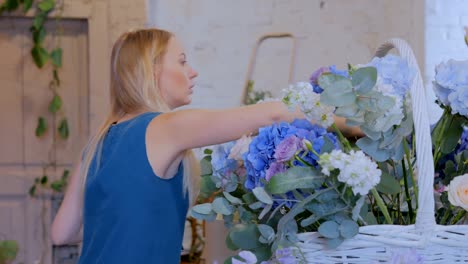 Florist-making-large-floral-basket-with-flowers-at-flower-shop