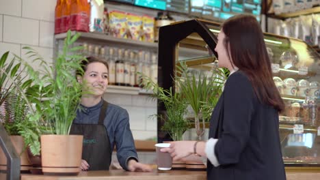 Mädchen-Brünette-bekommt-Kaffee-von-der-Barista-und-mit-lächelnden-ausgehen