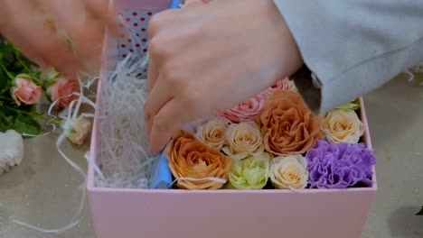 Professional-florist-making-gift-box-with-flowers-at-flower-store