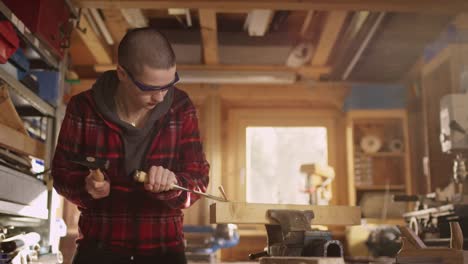 Young-woman-working-with-hammer-and-carving