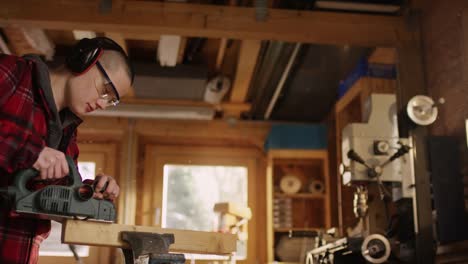 Feminine-young-woman-with-buzz-hair-working-with-planing-machine