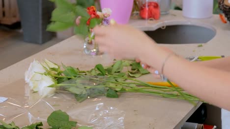 Professional-floral-artist-working-with-flowers-at-studio