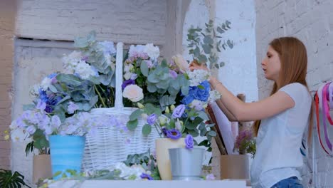 Florist-making-large-floral-basket-with-flowers-at-flower-shop