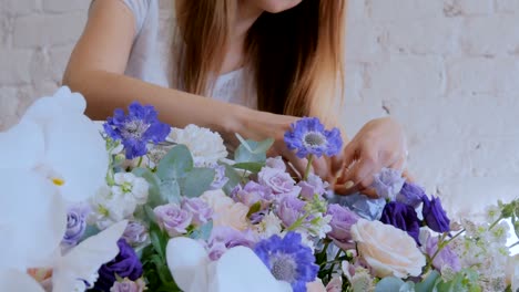 Florist-making-large-floral-basket-with-flowers-at-flower-shop