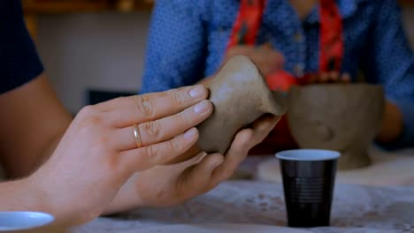 Man-making-mug-in-pottery-studio-workshop