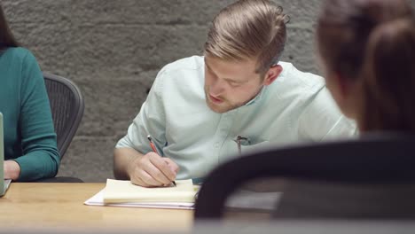 Man-hört-und-Notizen-in-einem-kleinen-Business-meeting