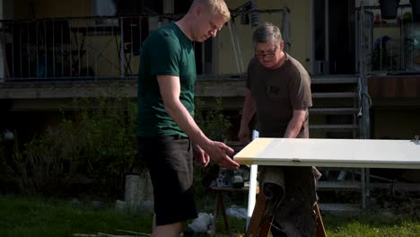 padre-e-hijo-reparacion-las-puertas-de-interiores-en-el-jardín-al-aire-libre