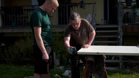 Vater-und-Sohn-reparieren-die-Innentüren-im-Garten-an-der-frischen-Luft