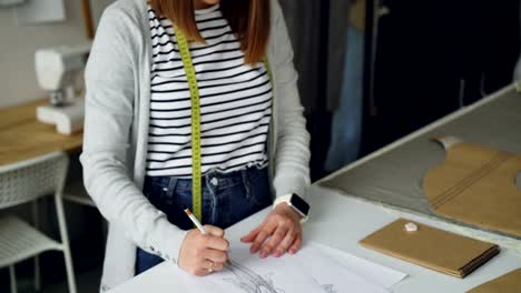 Tilt-Up-Schuss-von-kreativen-Modedesigner-konzentrierte-sich-auf-die-Skizze-des-Frauen-Kleidungsstück-auf-Papier-mit-Bleistift.-Modische-Kleidung-Konzept-schaffen.