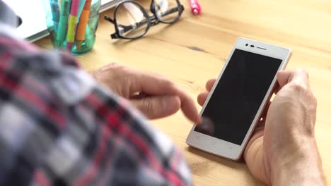 Businessman-in-Black-Scott-Shirt-Slide-Zoom-Touch-Smartphone-in-Home-Office