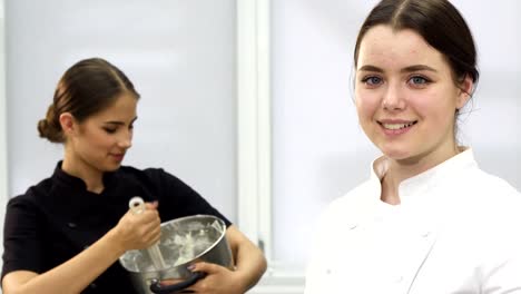 Hermosa-joven-chef-mujer-sonriendo-a-la-cámara-en-la-cocina