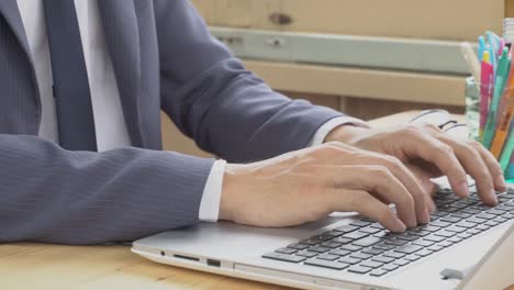 Hombre-de-negocios-en-traje-de-escribir-portátil-en-oficina-en-casa.-Trabajo-y-la-comunicación-por-Internet