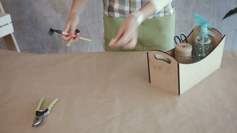 Florist-hands-laying-out-floristic-tools-on-table