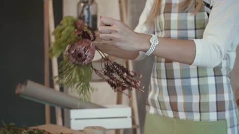 Florist-making-beautiful-bouquet-at-flower-shop