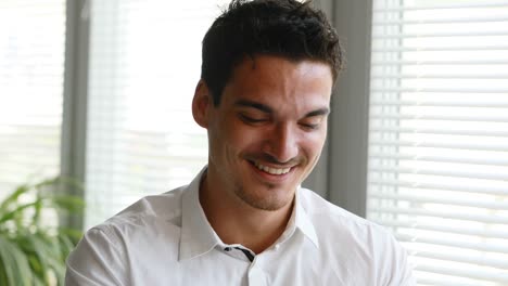 man-working-happily-at-his-laptop-in-the-office