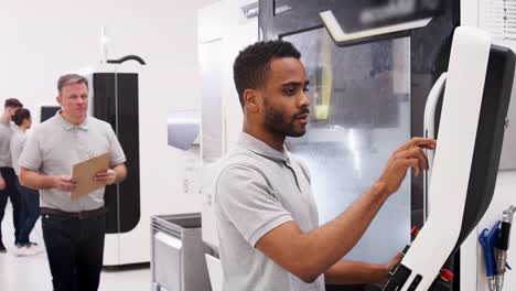 Ingeniero-formación-hombre-aprendiz-utilizar-CNC-de-la-máquina-en-la-fábrica