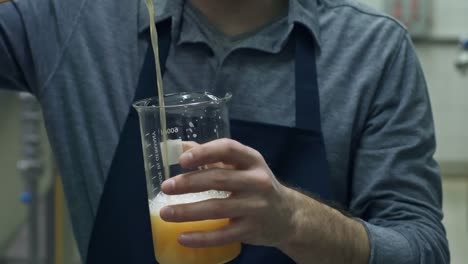 Man-gießt-Bier-in-Messung-Krug-in-der-Brauerei