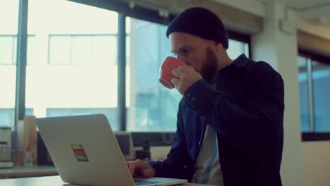 Man-drinks-coffee-while-working-in-the-startup-office