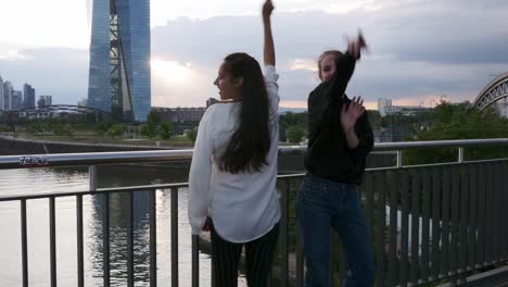 Amigas-bailando-en-el-puente-sobre-el-río