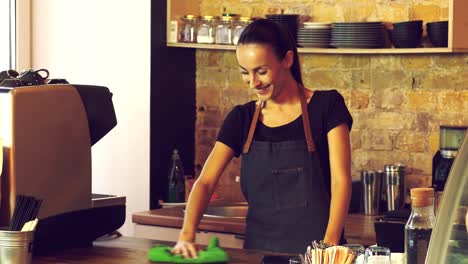 The-owner-of-a-coffee-house-wipes-a-wooden-table.