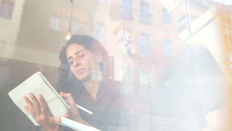 Two-business-women-brainstorm-together-with-electronic-device-on-a-casual-and-friendly-meeting