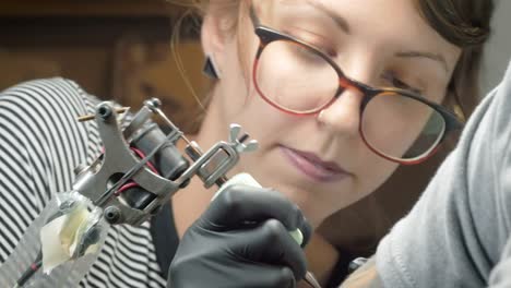 Young-Woman-Tattoo-Artist-Giving-Someone-a-Tattoo-in-4K