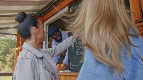 Two-girls-placing-an-order-outside-food-trailer