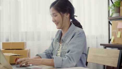 Beautiful-smart-Asian-young-entrepreneur-business-woman-owner-of-SME-online-checking-product-on-stock-and-save-to-computer-working-at-home.-Small-business-owner-at-home-office-concept.