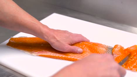 male-chef-slicing-smoked-salmon-fillet-at-restaurant-kitchen