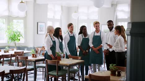 Team-Meeting-von-Führungskräften-und-Mitarbeitern-vor-dem-Restaurant-öffnet