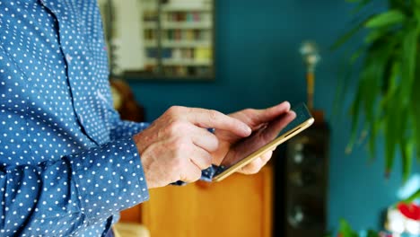 Businessman-Swiping-Through-Digital-Tablet-At-Home-Office