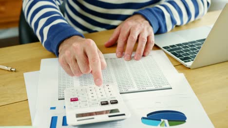 Businessman-Analysing-And-Calculation-Financial-Data-At-His-Desk