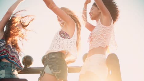 Girl-friends-dancing-in-vehicle-at-beach-on-road-trip