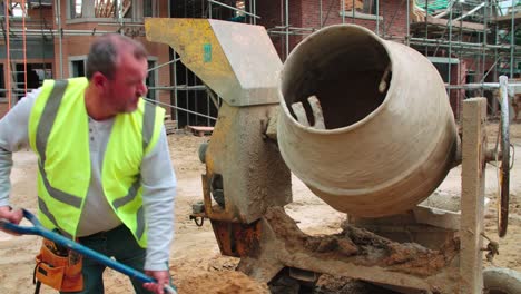 Construction-Worker-On-Building-Site-Mixing-Cement