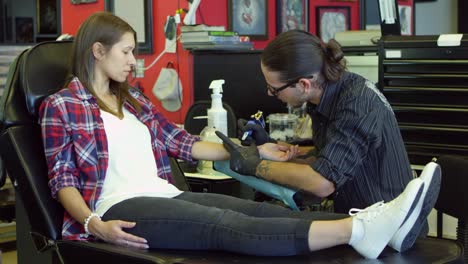 Woman-Sits-In-Chair-Having-Tattoo-In-Parlor-Shot-On-R3D