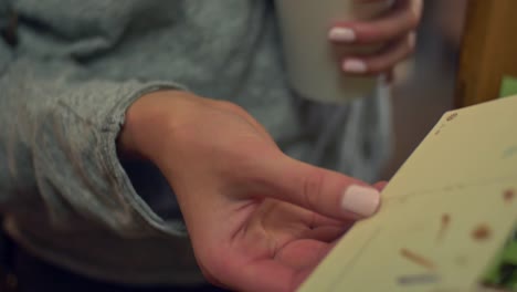 Close-up-of-somebody-looking-through-a-box-of-antique-postcards