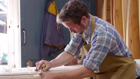 Man-Shaping-Custom-Surfboard-In-Workshop-Shot-On-RED-Camera