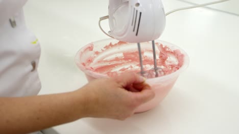 Close-Up-Of-Woman-In-Bakery-Whisking-Icing-For-Decoration