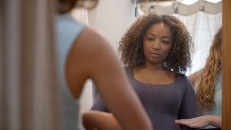 Woman-in-changing-room-with-friend-trying-on-dress,-close-up