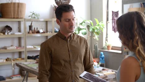 Man-authorising-card-payment-in-a-shop-with-tablet-computer