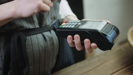 Woman-swiping-credit-card-through-credit-card-reader